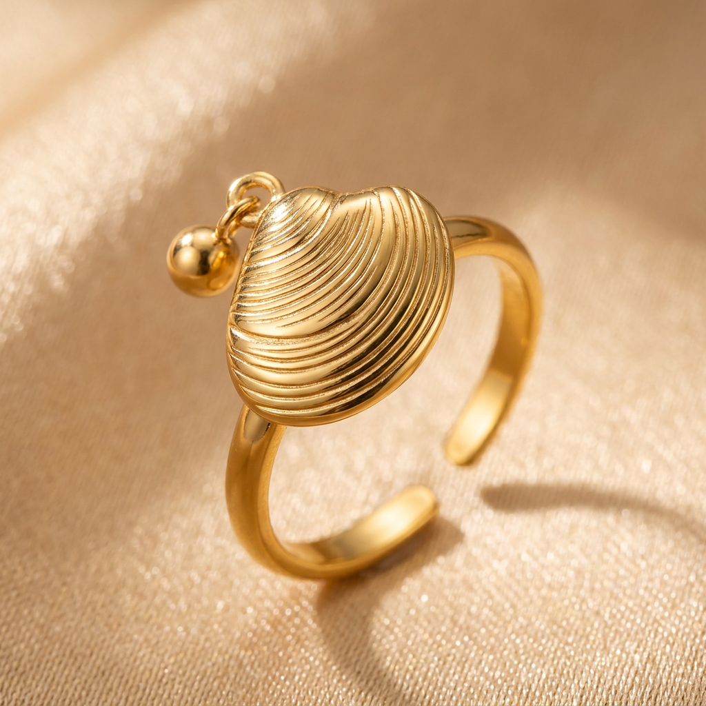 Close-up of curved shell ridges and open band on a gold-tone ring.