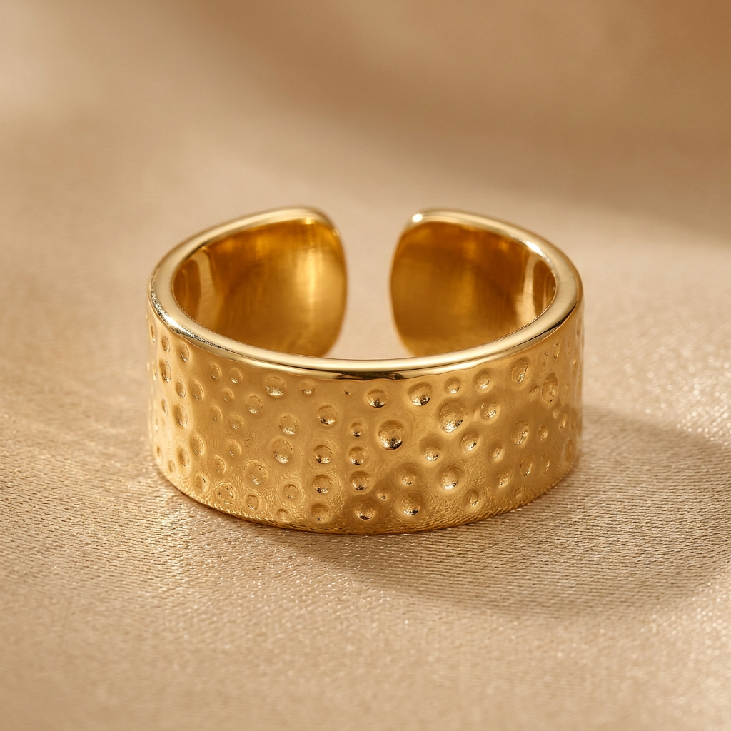 Close-up of textured free-size gold-tone ring showing separated band ends.
